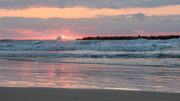 日没時の太陽から砕波 - sailboat sunset tel aviv sea ストックフォトと画像