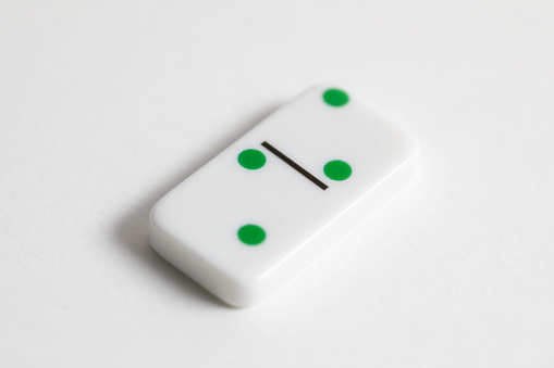 Domino game piece shot up against a white background, two