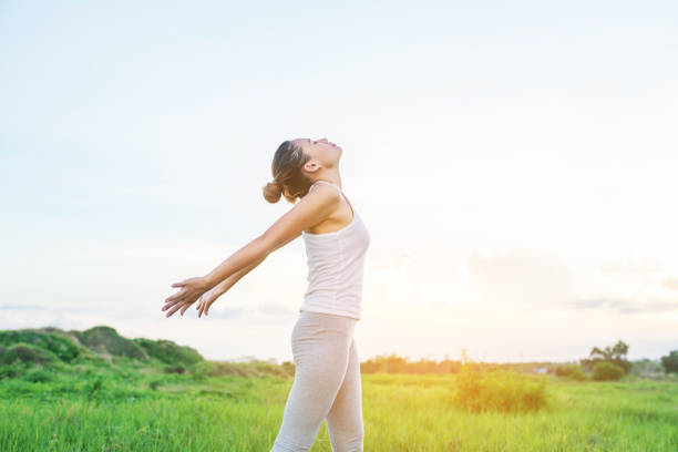 Healthy woman : Young woman spreading hands with joy the sun at meadows.