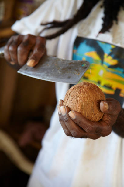 istock Afro Caribbean Man Shelling Coconut 918773744