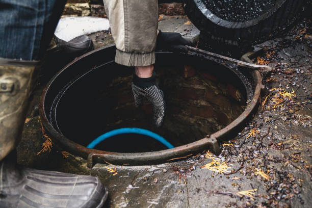 Hand in glove falls into sewer stock photo