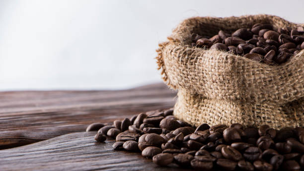istock Coffee beans in sackcloth on table close up 918793424