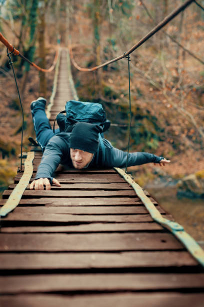 Man Hanging on Wooden Bridge