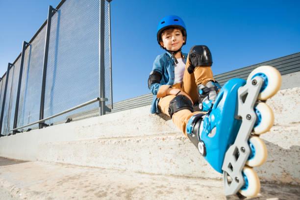 istock Roller boy resting on the steps of skate park 918802474