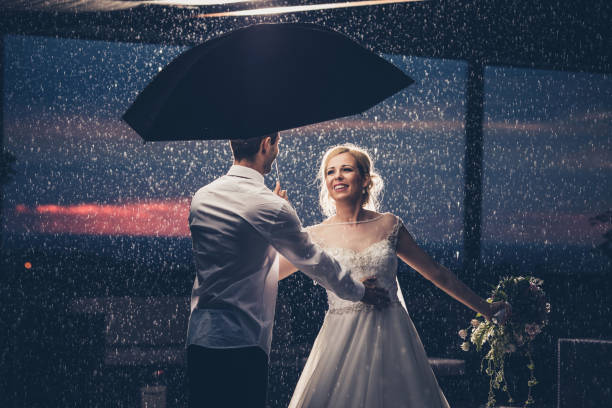 istock Happily married couple dancing on a rain. 918802678