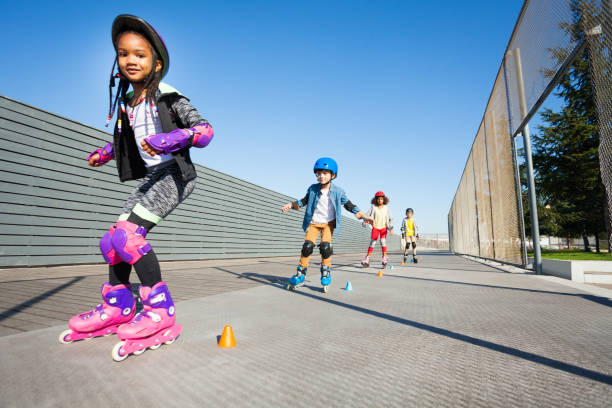 Portrait of preteen African girl learning to rollerblade outdoors in summer