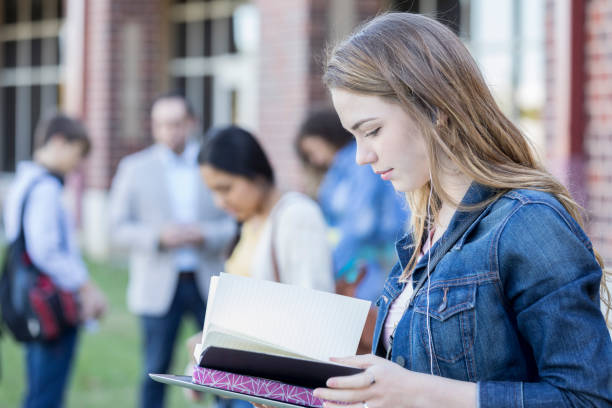 istock High school girl reads while waiting for school to start 918805660