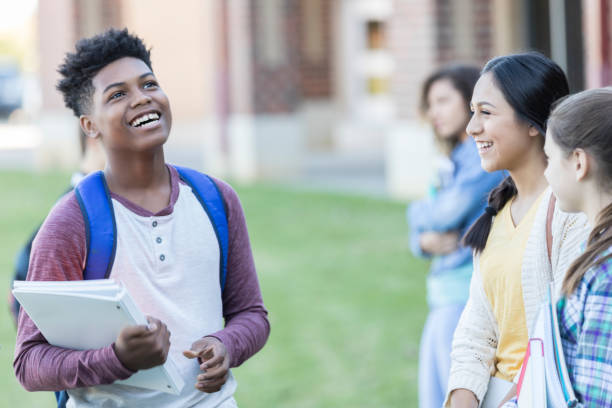 istock Handsome teenage boy talks with friends before school 918805662