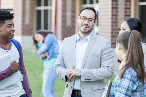 istock Group of students talk with principal before school 918805664