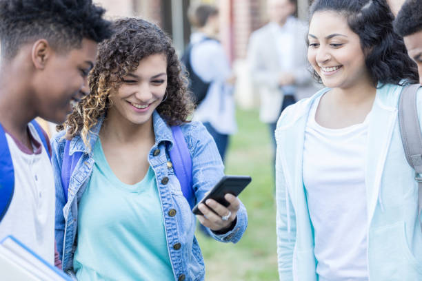 istock High school students watch video on smartphone 918805698