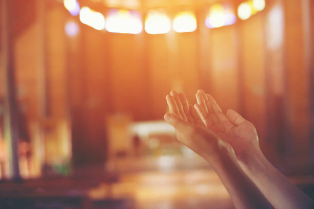 istock Young woman's hands clasped in prayer at christ church 918806020