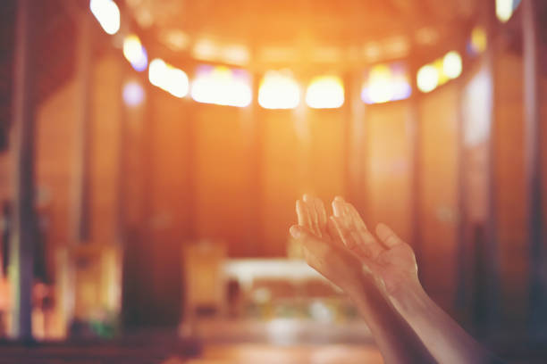 istock Young woman's hands clasped in prayer at christ church 918806058