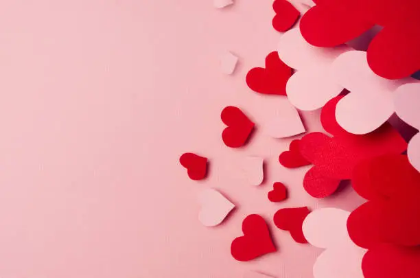 Photo of Valentine day background of fly paper red and pink hearts on pink color backdrop. Copy space.