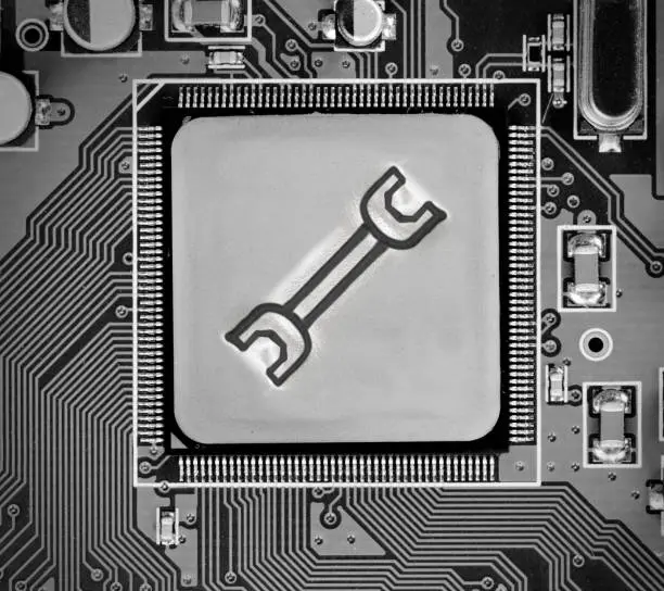 Macro photo of circuit board and chip with Spanner icon imprinted on metal surface