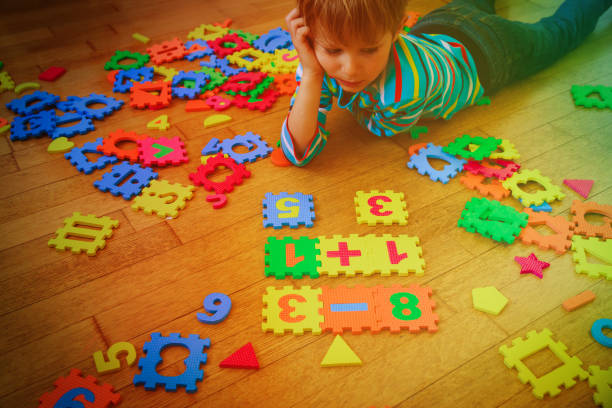 istock little boy playing with puzzle, education concept 918818478