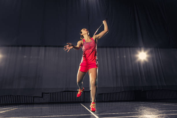 giovane donna che gioca a badminton in palestra - badminton school gymnasium shuttlecock sport foto e immagini stock