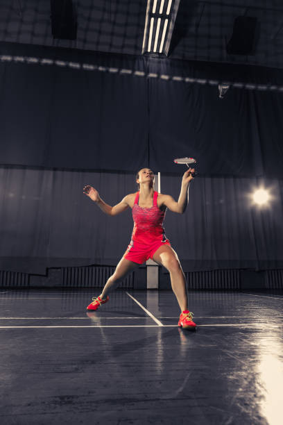 jovem mulher jogando badminton no ginásio - badminton school gymnasium shuttlecock sport - fotografias e filmes do acervo