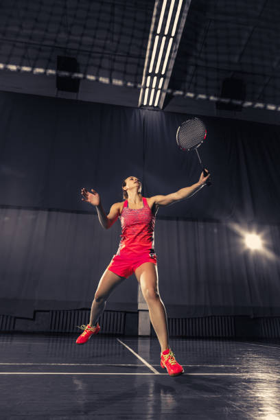 giovane donna che gioca a badminton in palestra - badminton school gymnasium shuttlecock sport foto e immagini stock