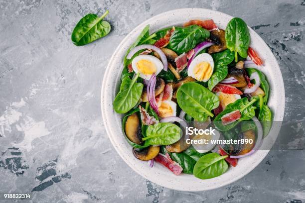 Lunch Bowl Of Spinach Salad With Bacon Mushrooms Eggs And Red Onions Stock Photo - Download Image Now