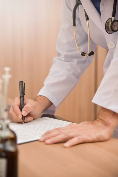 istock Asian male doctor is writing something on clipboard. 918824426
