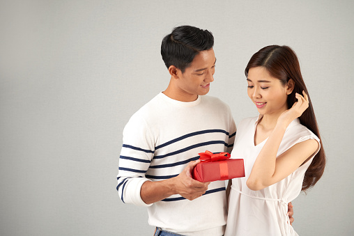 Young Asian man giving gift to his beautiful girlfriend on Valentines day
