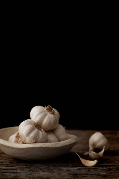 istock Still life of garlic bulb in dark black background 918824924