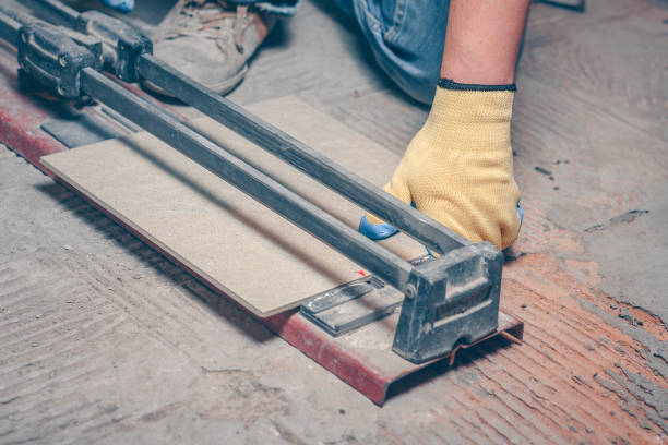 istock Tiler with a hand-held tile cutter cuts the tile on the floor 918825208