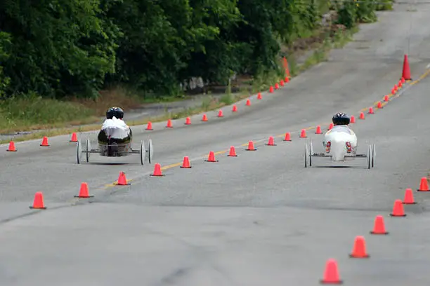 To children race down a soap box derby track.