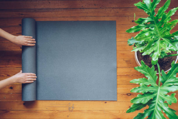 istock Woman rolling her mat after a yoga class, top view 918838786