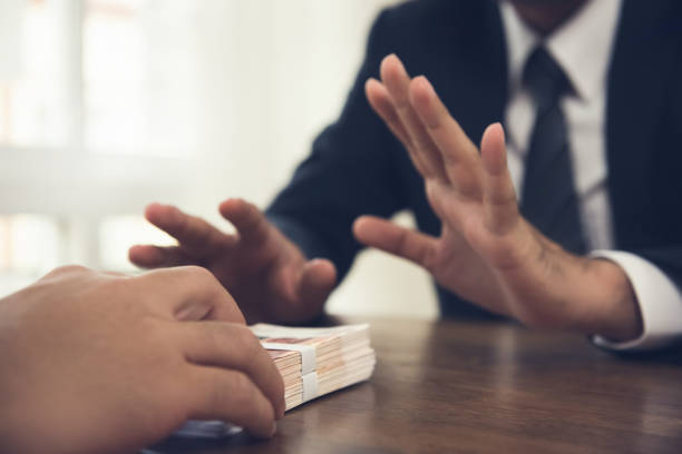 Businessman rejecting money offered by his partner Businessman rejecting money offered by his partner - anti bribery concept corruption stock pictures, royalty-free photos & images