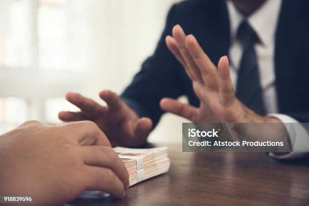 Businessman Rejecting Money Offered By His Partner Stock Photo - Download Image Now - Corruption, Bribing, Rejection