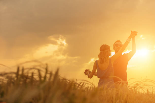 Couple dancing in a wheat field under the sunlight.