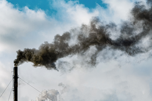 Dark black smoke from the chimney. Factory chimney smoking, heavy black smoke on the sky. ecology problems