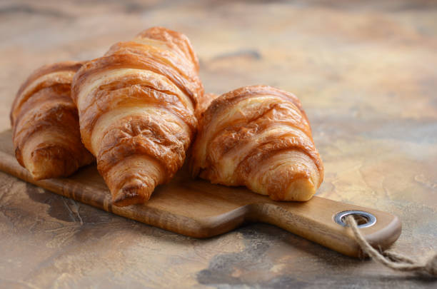 istock Fresh Croissants on a Wooden Cutting Board 918839966