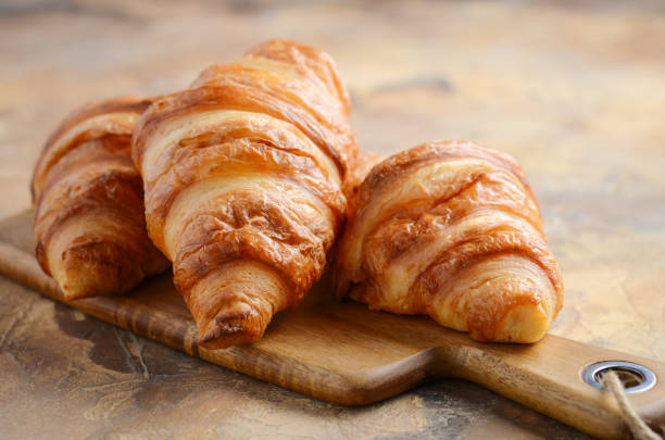 istock Fresh Croissants on a Wooden Cutting Board 918839976