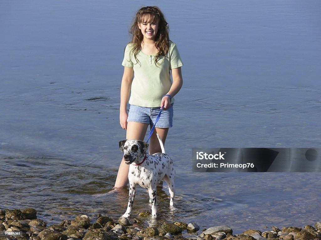 Chica y perro en el río - Foto de stock de Dálmata libre de derechos