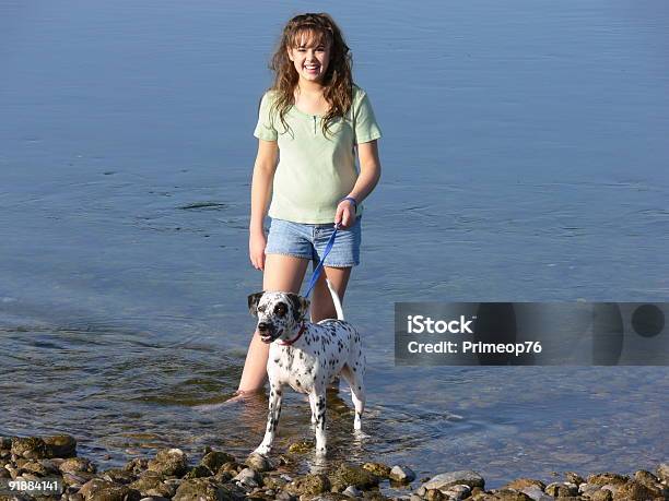 Chica Y Perro En El Río Foto de stock y más banco de imágenes de Dálmata - Dálmata, Grupo de personas, Adolescente