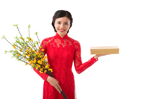 Beautiful smiling young woman with blooming apricot branches and present for Chinese New Year celebration