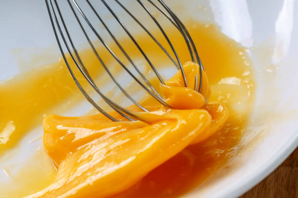 whisking the eggs with a whisk. White background. Macro stock photo