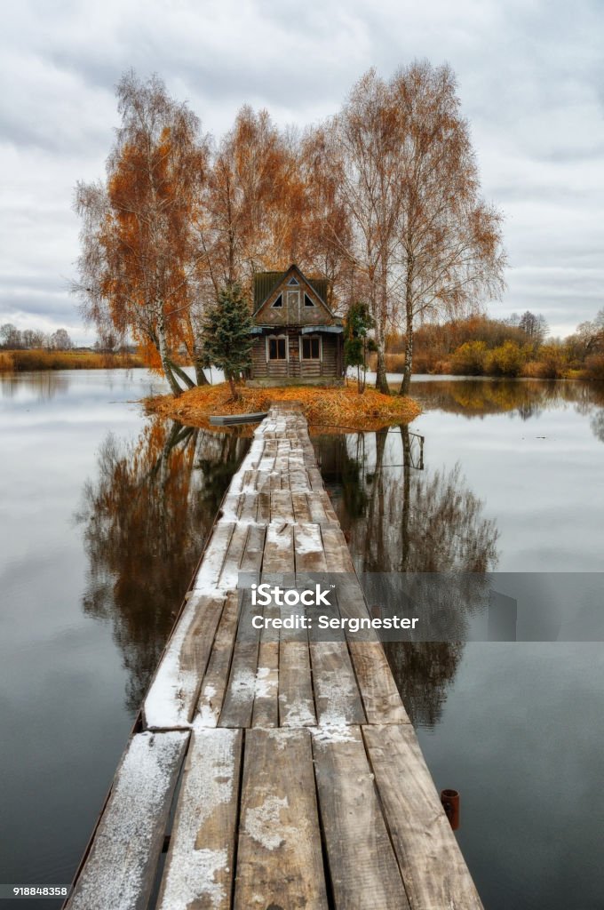 House on the island. Bridge on a river to a picturesque hut House Stock Photo