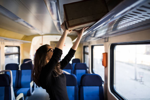 istock Woman putting her baggage on train grid compartment lifting commuter 918855216