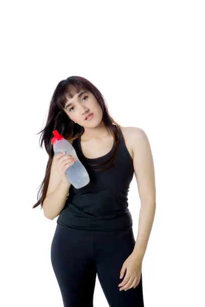 Portrait of Arabian girl wearing sportswear while holding a water bottle, isolated on white background