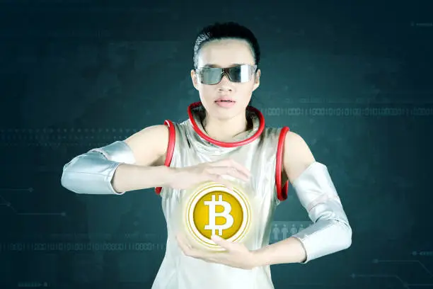Picture of beautiful woman holding a bitcoin symbol in her hands, shot with virtual screen background