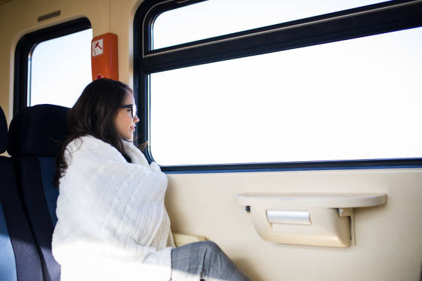 istock Young beautiful woman looking through the train window. 918868748