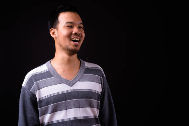 istock Portrait Of Asian Man Against Black Background 918869310