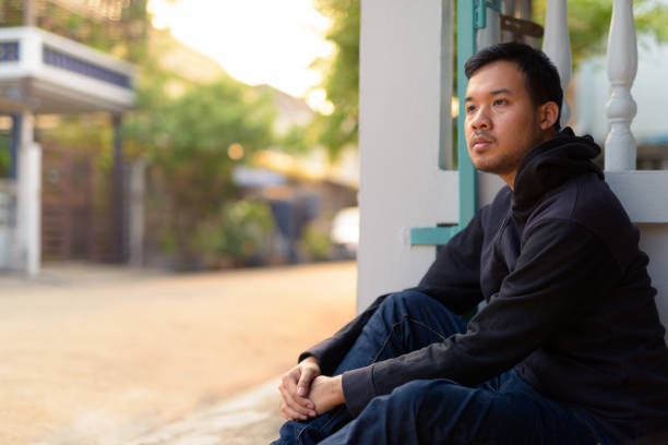 istock Asian Man Sitting And Thinking Outdoors 918869976