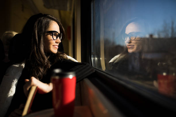 istock Young beautiful woman looking through the train window. 918873158