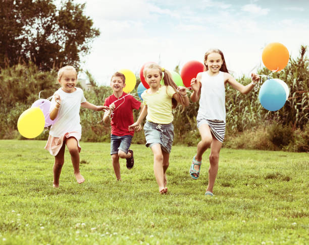 istock Children running and holding balloons 918876342