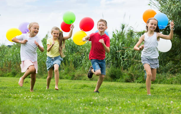 istock Girls and boy with balloons 918876350