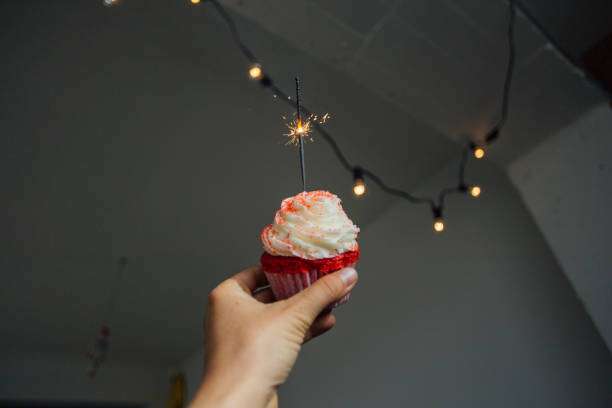 istock Hand holds pink sweet cupcake with sparkle 918876968
